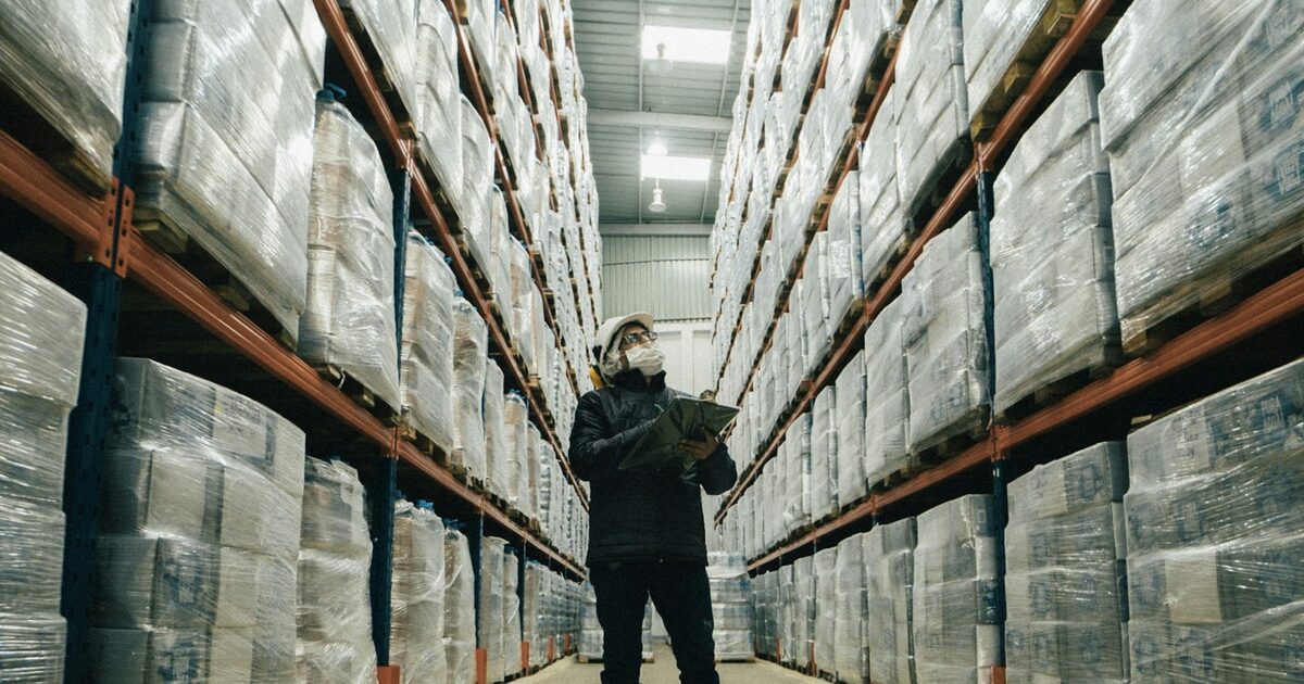 Worker using ERP on smartphone in warehouse