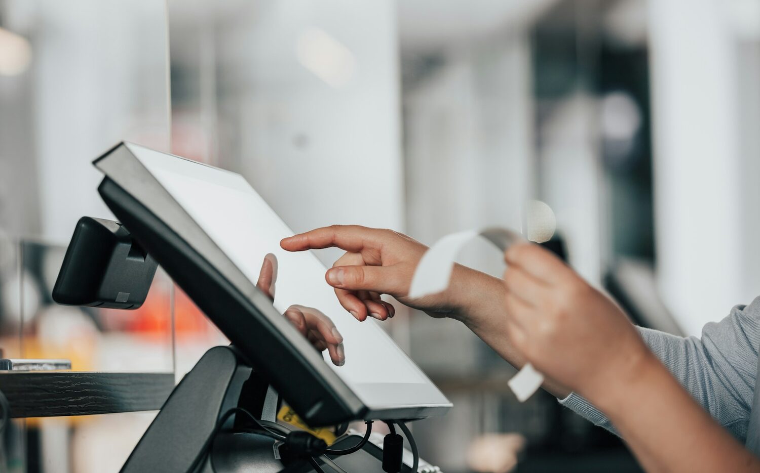 Staff using tablet POS at checkout counter